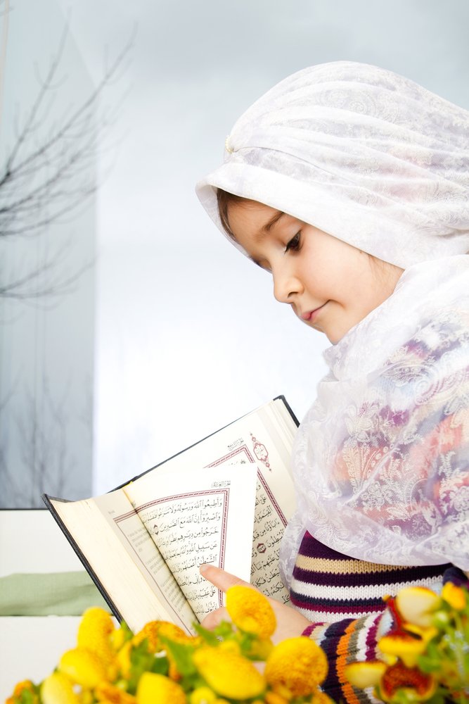 Woman in hijab holding a holy book